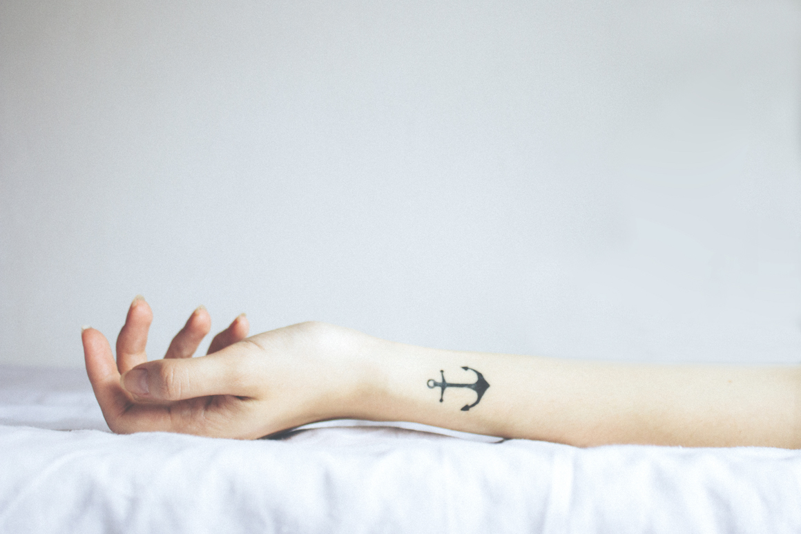 white woman's arm with anchor tattoo