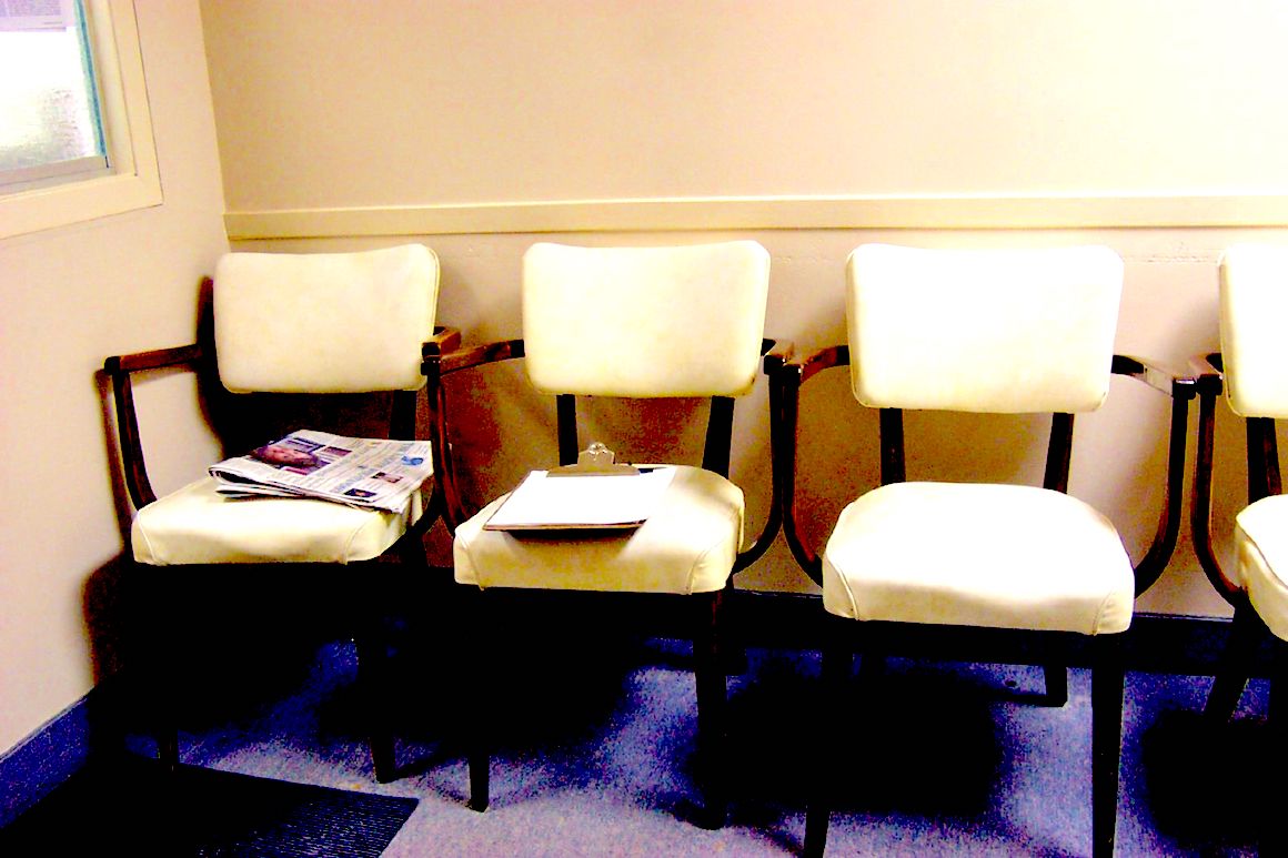 three white chairs in an empty waiting room